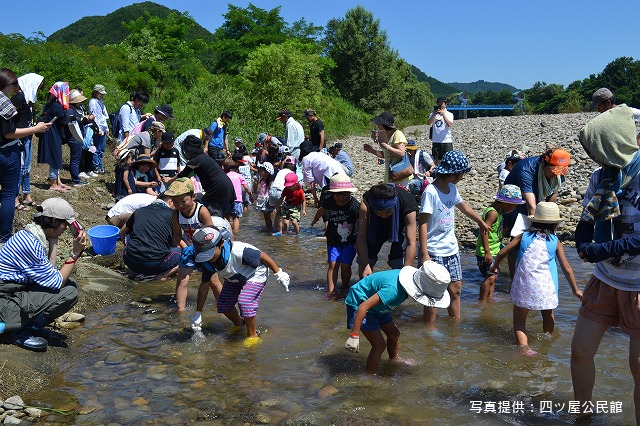 写真:河川敷で魚とりを行う住民