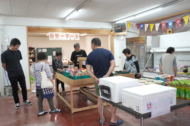 買い物しながら談笑する住民の写真