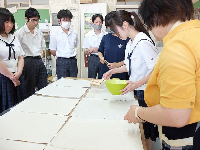 写真：十文字和紙に強化剤を塗る