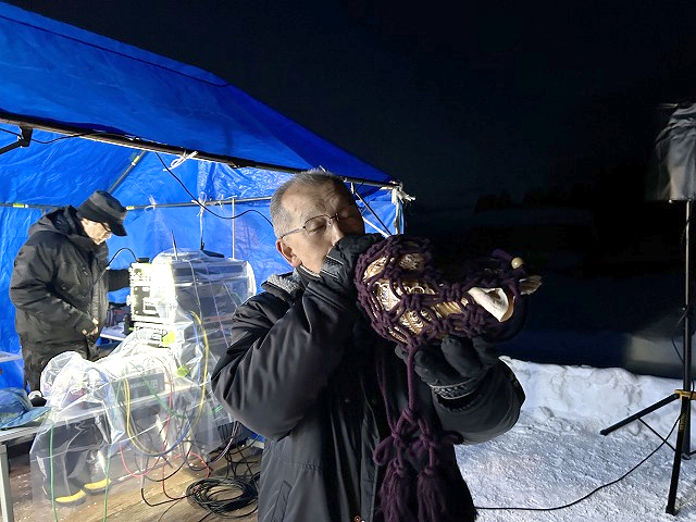 画像：ほら貝をふく住民の男性