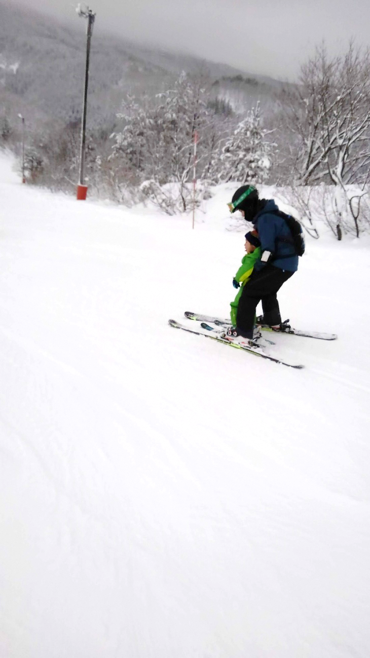  子どもと一緒にスキーを滑る写真[1068KB]